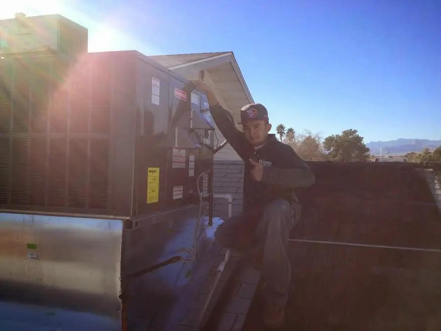 HVAC technician performing AC Tune-Up on a rooftop unit in Panama City Beach
